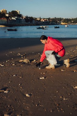 Kadın bir çevre bilimci plastikten ve diğer atıklardan sahili temizliyor. Çöp geri dönüşümü ve çevresel bakım kavramı. Bir serinin parçası