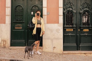 Gözlem güvertesindeki orta yaşlı gezgin kadın Portekiz 'deki Lizbon manzarasının güzel bir kamerasıyla fotoğraf çekiyor. Seyahat ve solo turizm konsepti. Dizinin bir parçası.