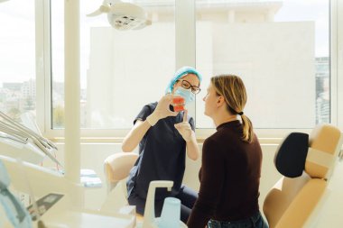 Orta yaşlı kadın, diş ve diş bakımı için diş hekimi, randevu ya da sağlık kontrolü. Diş beyazlatma, temizlik ya da oral, hastanede ağız ve sakız bakımı. Yumuşak odaklanma. Dizinin bir parçası. Yakın plan..