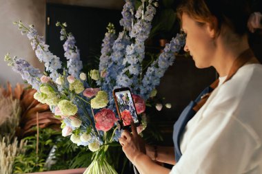 Küçük çiçekçi dükkanı. Bir kadın video blogu ya da çevrimiçi kurs yazar. Çiçek okulu konsepti. Çiçekçi kadın çiçek aranjmanı yapar. - Evet. Yerel bir iş. Bir serinin parçası.