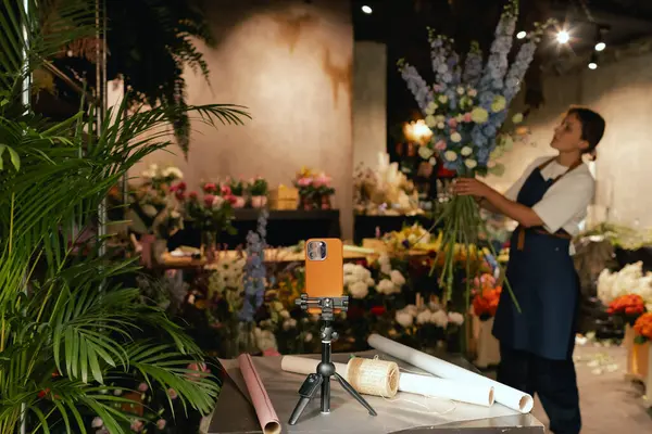 Küçük çiçekçi dükkanı. Bir kadın video blogu ya da çevrimiçi kurs yazar. Çiçek okulu konsepti. Çiçekçi kadın çiçek aranjmanı yapar. - Evet. Yerel bir iş. Bir serinin parçası.