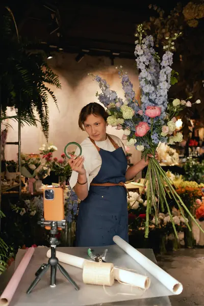 Küçük çiçekçi dükkanı. Bir kadın video blogu ya da çevrimiçi kurs yazar. Çiçek okulu konsepti. Çiçekçi kadın çiçek aranjmanı yapar. - Evet. Yerel bir iş. Bir serinin parçası.