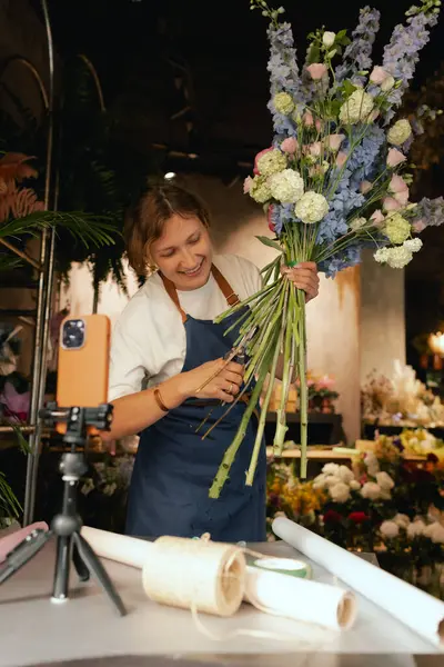 Küçük çiçekçi dükkanı. Bir kadın video blogu ya da çevrimiçi kurs yazar. Çiçek okulu konsepti. Çiçekçi kadın çiçek aranjmanı yapar. - Evet. Yerel bir iş. Bir serinin parçası.