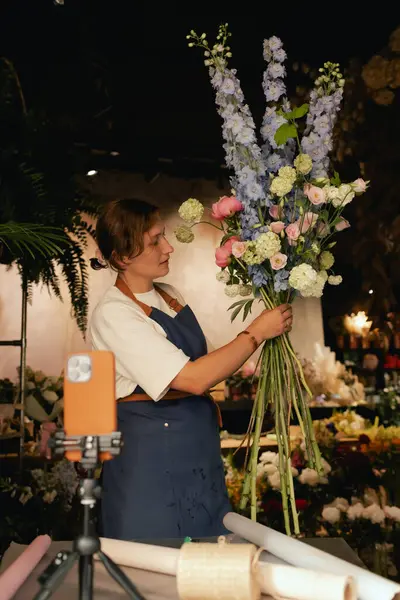 Küçük çiçekçi dükkanı. Bir kadın video blogu ya da çevrimiçi kurs yazar. Çiçek okulu konsepti. Çiçekçi kadın çiçek aranjmanı yapar. - Evet. Yerel bir iş. Bir serinin parçası.