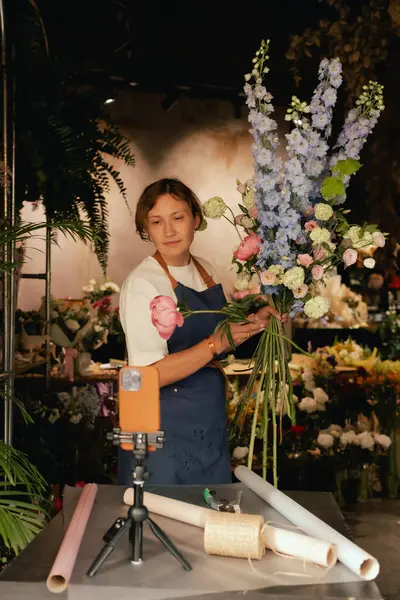 Küçük çiçekçi dükkanı. Bir kadın video blogu ya da çevrimiçi kurs yazar. Çiçek okulu konsepti. Çiçekçi kadın çiçek aranjmanı yapar. - Evet. Yerel bir iş. Bir serinin parçası.