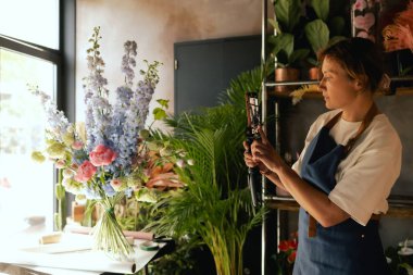 Küçük çiçekçi dükkanı. Bir kadın video blogu ya da çevrimiçi kurs yazar. Çiçek okulu konsepti. Çiçekçi kadın çiçek aranjmanı yapar. - Evet. Yerel bir iş. Bir serinin parçası.