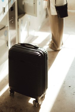 Tren istasyonundaki bagaj deposunda bavullu gezgin kadın. İş seyahati ve yalnız turizm konsepti. Zombi Kız Etkilenen Sokakta Sosyal medya hikayeleri çekiyor. Dizinin bir parçası