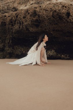 Kumsalda, okyanusta, doğayla bütünleşen, sağlıklı bir hayat tarzı olan neşeli, özgür bir kadın. Solo turizm. Bir serinin parçası.