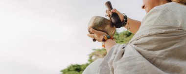 Ses iyileştirici aletleri tutan kadın ellerinin yakın çekimi. Terapi, iç denge ve titreşim, niyet ve derin varlık yoluyla kendini keşfetme araçları. Bir ton antika. Yumuşak odaklı, bulanık.