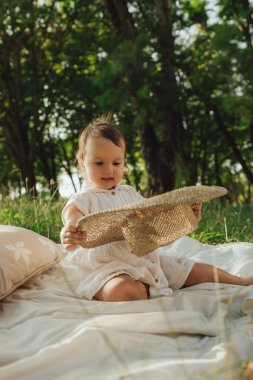 Güneşli bir parkta oynayan mutlu küçük kız. Çocukluk sevinci, Anneler Günü, açık hava aktivitesi, erken öğrenme, hayal gücü, otantik an, duygusal çocukluk, doğal ışık. Bir serinin parçası.