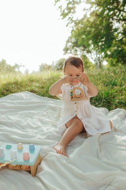 Güneşli bir parkta oynayan mutlu küçük kız. Çocukluk sevinci, Anneler Günü, açık hava aktivitesi, erken öğrenme, hayal gücü, otantik an, duygusal çocukluk, doğal ışık. Bir serinin parçası.