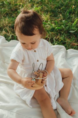 Güneşli bir parkta oynayan mutlu küçük kız. Çocukluk sevinci, Anneler Günü, açık hava aktivitesi, erken öğrenme, hayal gücü, otantik an, duygusal çocukluk, doğal ışık. Bir serinin parçası.