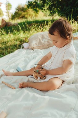 Güneşli bir parkta oynayan mutlu küçük kız. Çocukluk sevinci, Anneler Günü, açık hava aktivitesi, erken öğrenme, hayal gücü, otantik an, duygusal çocukluk, doğal ışık. Bir serinin parçası.