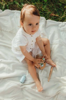 Güneşli bir parkta oynayan mutlu küçük kız. Çocukluk sevinci, Anneler Günü, açık hava aktivitesi, erken öğrenme, hayal gücü, otantik an, duygusal çocukluk, doğal ışık. Bir serinin parçası.