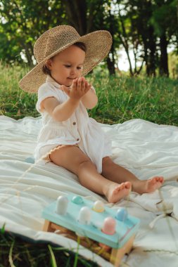 Güneşli bir parkta oynayan mutlu küçük kız. Çocukluk sevinci, Anneler Günü, açık hava aktivitesi, erken öğrenme, hayal gücü, otantik an, duygusal çocukluk, doğal ışık. Bir serinin parçası.