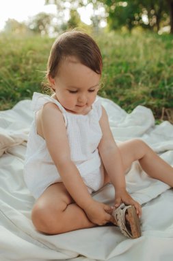 Güneşli bir parkta oynayan mutlu küçük kız. Çocukluk sevinci, Anneler Günü, açık hava aktivitesi, erken öğrenme, hayal gücü, otantik an, duygusal çocukluk, doğal ışık. Bir serinin parçası.