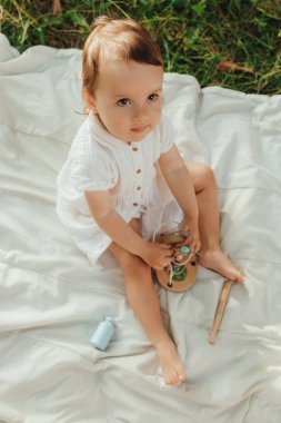 Güneşli bir parkta oynayan mutlu küçük kız. Çocukluk sevinci, Anneler Günü, açık hava aktivitesi, erken öğrenme, hayal gücü, otantik an, duygusal çocukluk, doğal ışık. Bir serinin parçası.