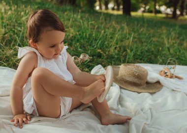 Güneşli bir parkta oynayan mutlu küçük kız. Çocukluk sevinci, Anneler Günü, açık hava aktivitesi, erken öğrenme, hayal gücü, otantik an, duygusal çocukluk, doğal ışık. Bir serinin parçası.