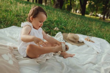 Güneşli bir parkta oynayan mutlu küçük kız. Çocukluk sevinci, Anneler Günü, açık hava aktivitesi, erken öğrenme, hayal gücü, otantik an, duygusal çocukluk, doğal ışık. Bir serinin parçası.