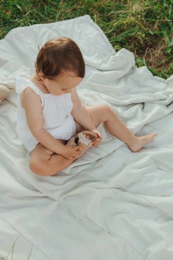 Güneşli bir parkta oynayan mutlu küçük kız. Çocukluk sevinci, Anneler Günü, açık hava aktivitesi, erken öğrenme, hayal gücü, otantik an, duygusal çocukluk, doğal ışık. Bir serinin parçası.