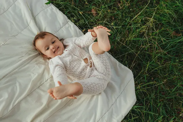 Güneşli bir parkta oynayan mutlu küçük kız. Çocukluk sevinci, Anneler Günü, açık hava aktivitesi, erken öğrenme, hayal gücü, otantik an, duygusal çocukluk, doğal ışık. Bir serinin parçası.
