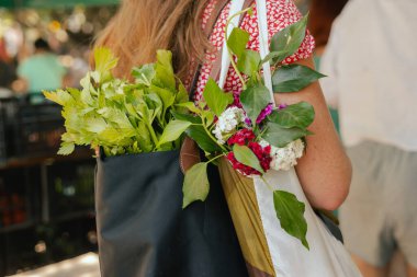 Yerel çiftçi pazarında elinde çiçeklerle bir alışveriş sepeti ile elini kapat. Olgun Kadın Müşteri Dükkanı 'ndan alışveriş yapıyor. Kapatın. Dizinin bir parçası