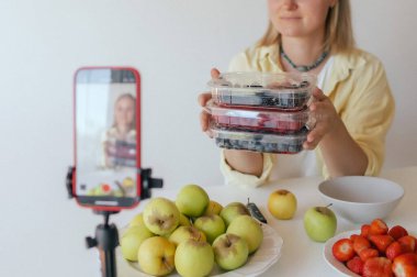 Orta yaşlı bir kadın ev yapımı meyve derisi hazırlıyor, sağlıklı bir atıştırmalık için mutfağında taze meyve dilimliyor. Organik ikramlar ve doğal yaşam üzerine bir serinin parçası. Kullanıcı tarafından oluşturulan içerik.