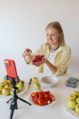 Orta yaşlı bir kadın ev yapımı meyve derisi hazırlıyor, sağlıklı bir atıştırmalık için mutfağında taze meyve dilimliyor. Organik ikramlar ve doğal yaşam üzerine bir serinin parçası. Kullanıcı tarafından oluşturulan içerik.