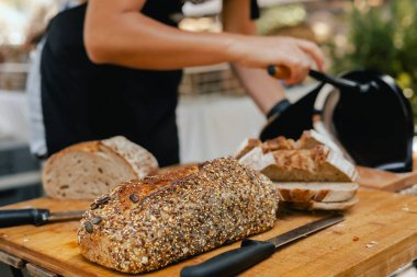 Yerel bir Portekiz fırınında el yapımı ekmek dilimleme. Sağlıklı beslenme ve geleneksel fırın konsepti. Kapatın. Dizinin bir parçası.