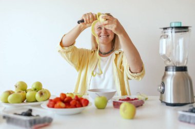 Mutfağında sağlıklı bir son sınıf öğrencisi var. Evde kendine sağlıklı vejetaryen yemekleri servis eden olgun bir kadın. Yaşlı vücuduna bakan bir kadın bitkisel beslenir..