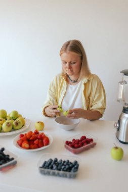 Mutfağında sağlıklı bir son sınıf öğrencisi var. Evde kendine sağlıklı vejetaryen yemekleri servis eden olgun bir kadın. Yaşlı vücuduna bakan bir kadın bitkisel beslenir..