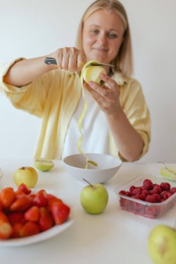 Mutfağında sağlıklı bir son sınıf öğrencisi var. Evde kendine sağlıklı vejetaryen yemekleri servis eden olgun bir kadın. Yaşlı vücuduna bakan bir kadın bitkisel beslenir..