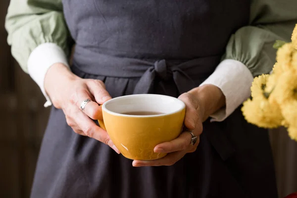 Das Mädchen Hält Eine Gelbe Tasse Tee Der Hand Zimtbrötchen — Stockfoto