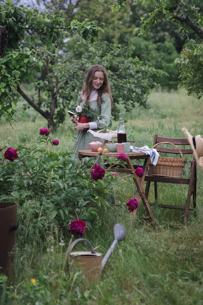 Κορίτσι Σερβίρει Ένα Τραπέζι Για Τσάι Πίνοντας Στον Κήπο Και — Φωτογραφία Αρχείου