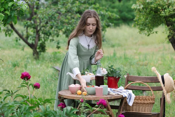 Κορίτσι Σερβίρει Ένα Τραπέζι Για Τσάι Πίνοντας Στον Κήπο Και — Φωτογραφία Αρχείου