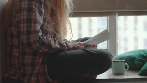 Teenager Mädchen Sitzt Auf Der Fensterbank Und Liest Ein Buch — Stockvideo