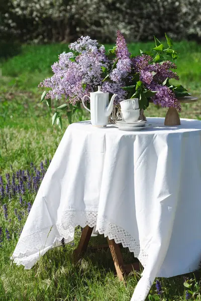 花瓶里有一束美丽的紫丁香 春天花园里有许多蛋糕 依然鲜活 免版税图库照片