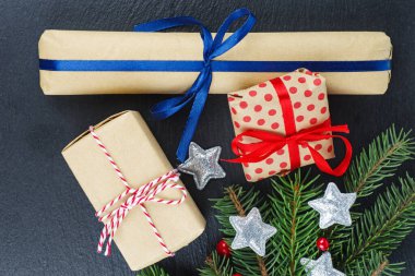 Siyah arka planda gümüş yıldızlı hediye kutuları, ladin (köknar) dalı