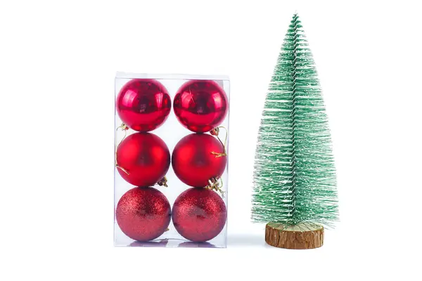 クリスマスの装飾 白い背景に隔離された赤い球および人工的な小さなクリスマスの木のセット ロイヤリティフリーのストック画像