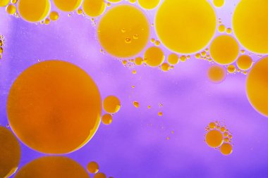 Suda petrol sondajı. Mor arkaplanda soyut kabarcıklar. Yağ damlacıklarıyla suda bozulma.