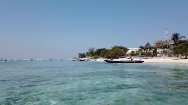 Gili Travangan, Endonezya - 9 Eylül 2019: Popüler ada turizm beldesinin turkuaz suyu ile sahile demir atmış tekneler