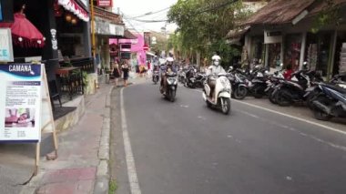 Ubud, Bali, Endonezya - 5 Eylül 2019: Popüler turizm kasabasının işlek bir caddesinde yürüyen insanlar, arabalar ve motosikletler