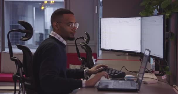 Молодий Афроамериканський Бізнесмен Або Програміст Окулярами Сидять Сучасному Офісі Співробітника — стокове відео