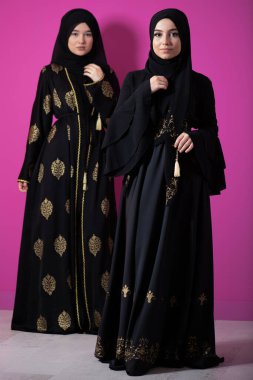 Modern pembe arka planda izole edilmiş iki güzel Müslüman kadın modern İslam ve Ramazan Kareem kavramını temsil ediyor.. 