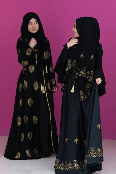 两名穿着时髦服装 被隔离在现代粉色背景下的劫机者的漂亮穆斯林妇女代表了现代伊斯兰教和拉马丹 卡里姆的概念 — 图库照片
