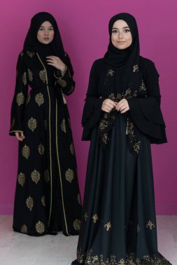 Modern pembe arka planda izole edilmiş iki güzel Müslüman kadın modern İslam ve Ramazan Kareem kavramını temsil ediyor.. 