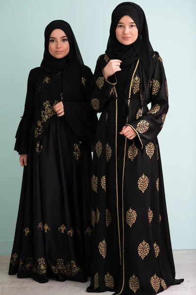 两名穿着时髦服装 被隔离在现代青色背景下的劫机者的漂亮穆斯林妇女代表了现代伊斯兰教和拉马丹 卡里姆的概念 — 图库照片