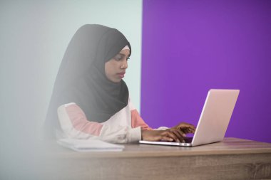 Başörtüsü takan afro kız evinde oturup dizüstü bilgisayar kullanırken hayal kırıklığına uğrayıp üzülüyor. Yüksek kalite fotoğraf