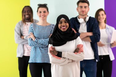 Çeşitli gençler renkli bir arkaplan önünde stüdyo fotoğrafı için poz verirken mobil cihazlar kullanıyorlar. Yüksek kalite fotoğraf