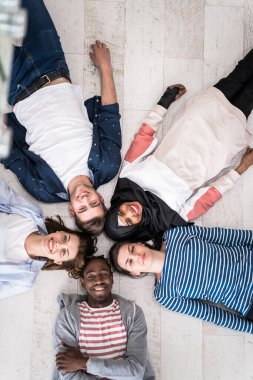 Zeminde yatan bir grup insanın üst görünüşü birlikteliği sembolize eder. Yüksek kalite fotoğraf